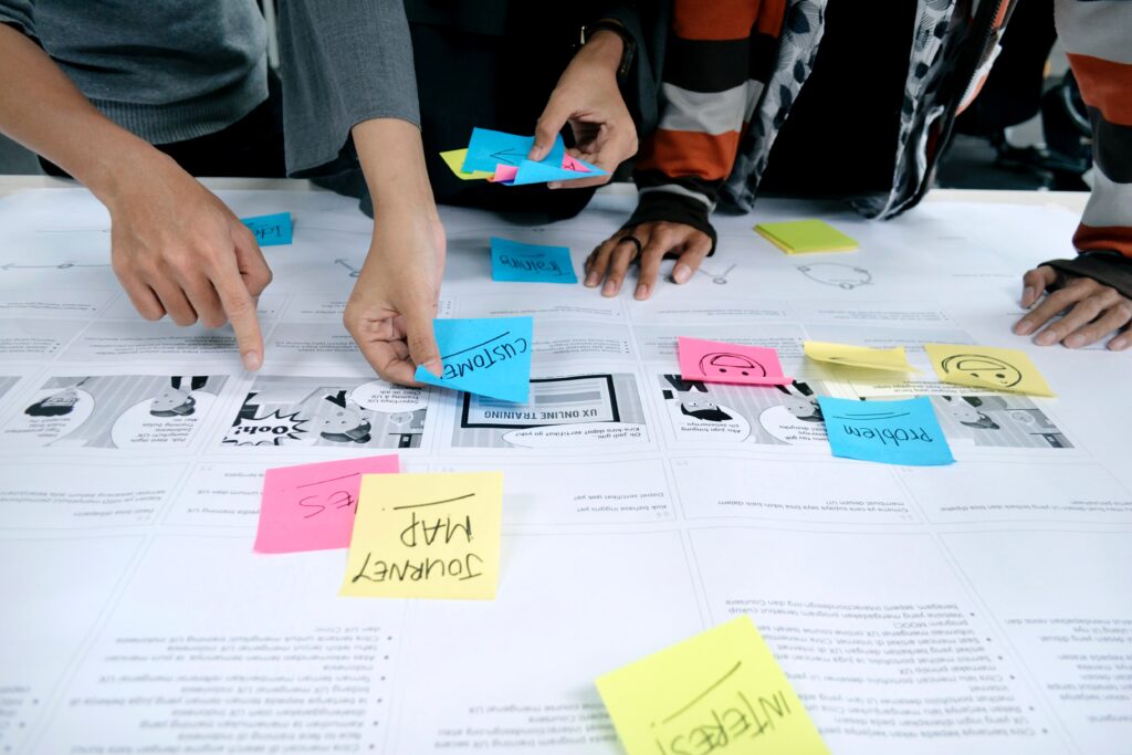 A group of people making notes on a plan with Post-It notes