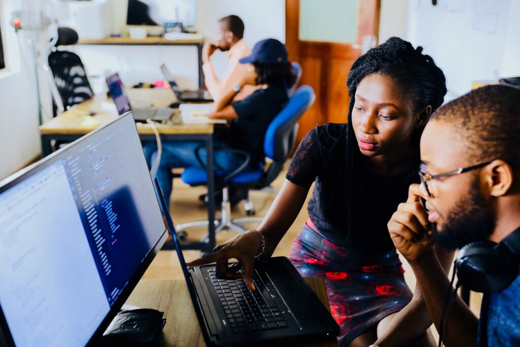 boss showing apprenticeship how to do a task on computer