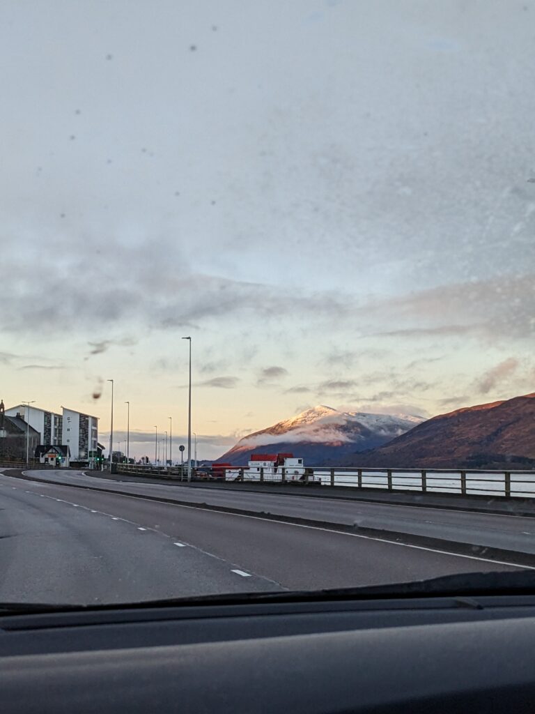 View of a Scottish mountain by the road from the driver's seat in a car