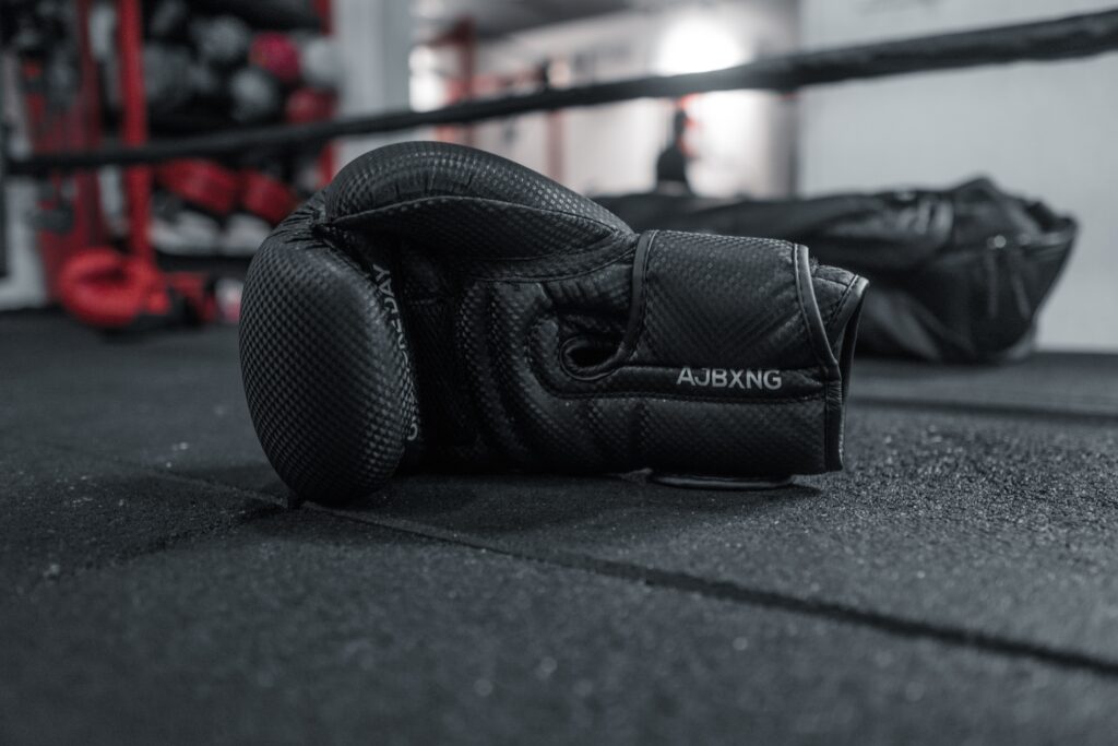 A pair of black boxing gloves on the boxing ring in the gym